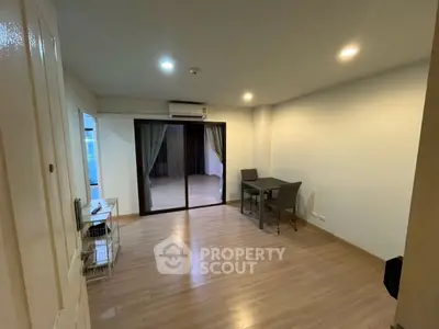 Spacious living room with modern decor and sliding glass doors leading to a balcony.