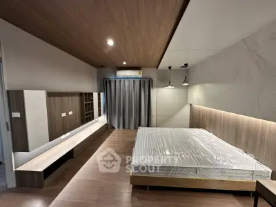 Modern bedroom with sleek design, wooden flooring, and ambient lighting in a contemporary apartment.