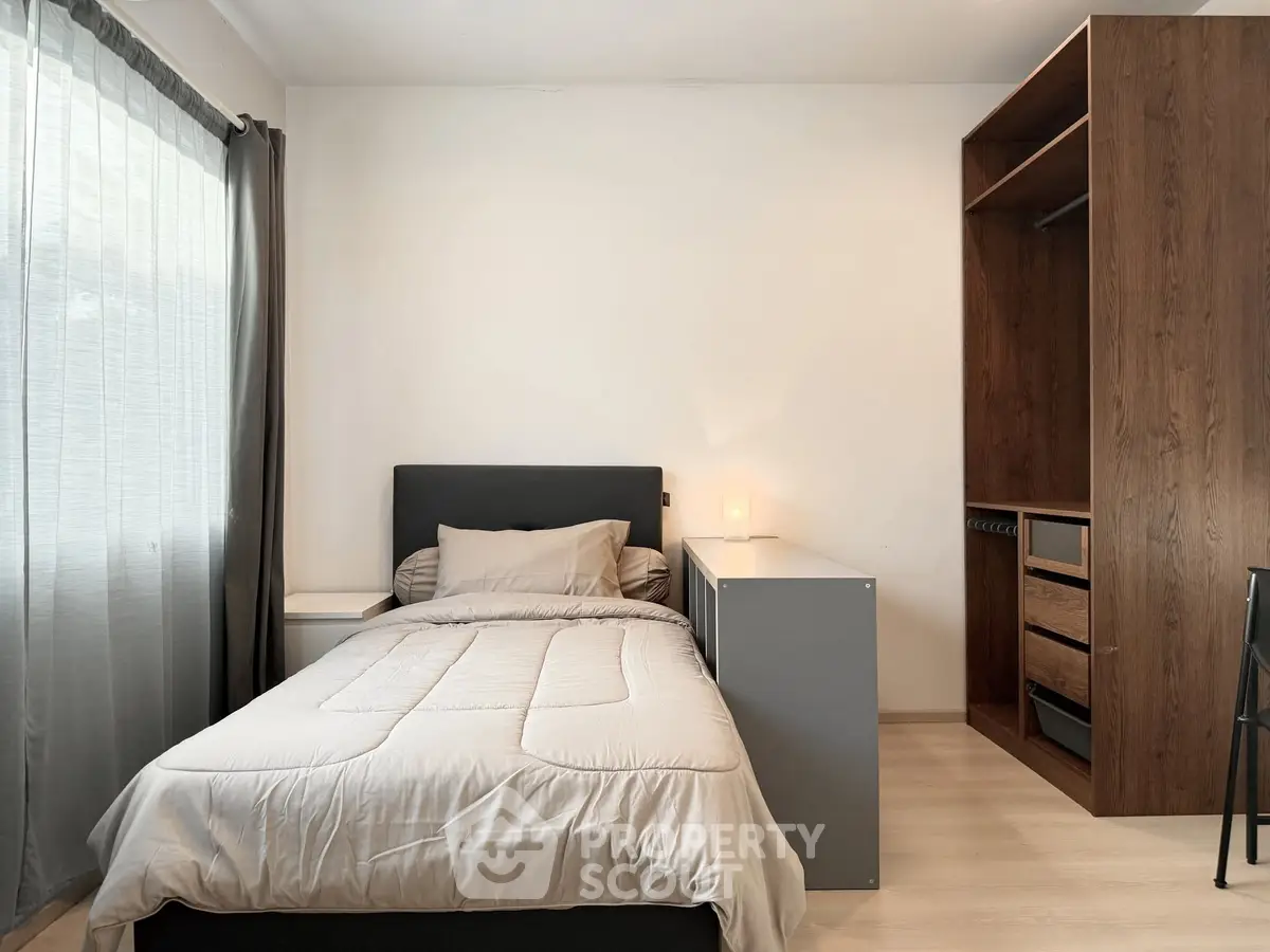 Modern bedroom with cozy bed and built-in wooden wardrobe, perfect for urban living.