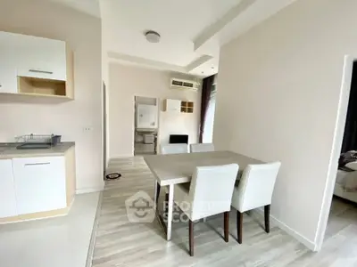 Modern dining area with sleek table and chairs in open-plan apartment