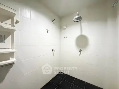 Spacious modern bathroom with dual shower heads and sleek tile design.
