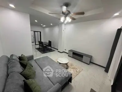 Spacious modern living room with elegant gray sofa and ceiling fan