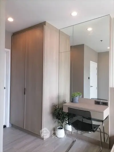 Modern study area with sleek desk and mirrored wall in stylish apartment.