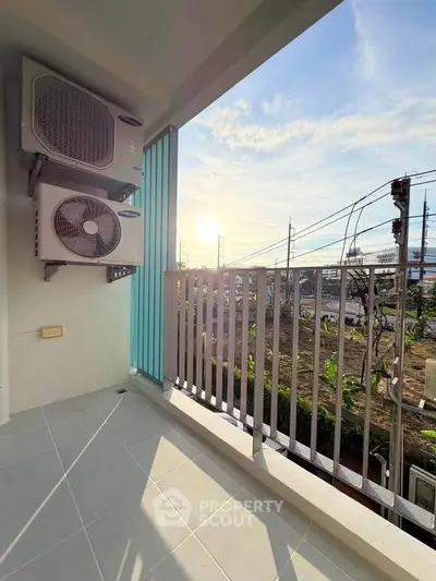 Charming balcony with air conditioning units and scenic view, perfect for relaxation and enjoying sunsets.