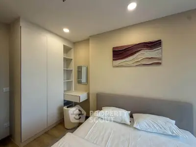 Modern bedroom with stylish decor and built-in storage in a cozy apartment.