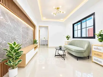 Modern living room with elegant lighting and stylish furniture, featuring a marble accent wall and large window.