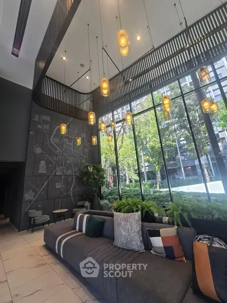 Luxurious modern lobby with high ceilings and large windows overlooking greenery.