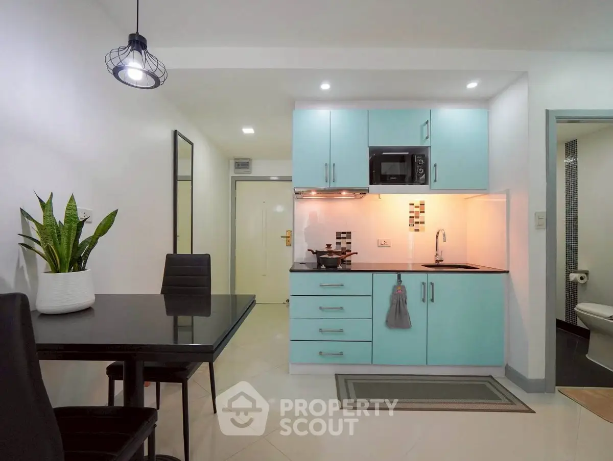 Modern kitchen with sleek cabinetry and dining area in a stylish apartment
