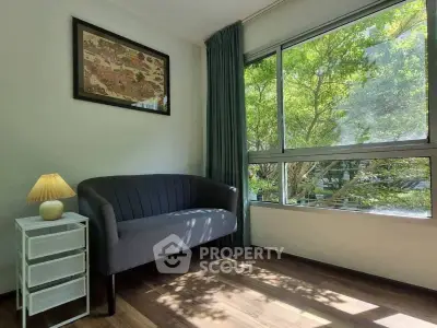 Bright living room corner with large window and cozy seating area