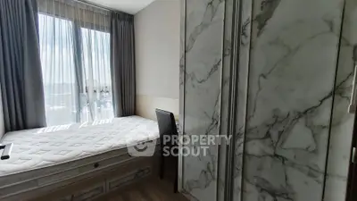 Modern bedroom with large window and marble-accented wardrobe