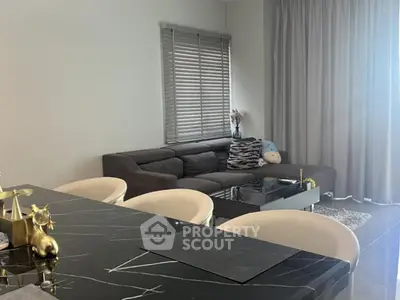 Modern living room with elegant black marble dining table and cozy gray sofa
