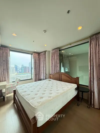 Spacious bedroom with city view and elegant wooden bed frame