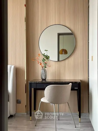 Stylish modern study nook with elegant desk, round mirror, and chic chair in cozy apartment.
