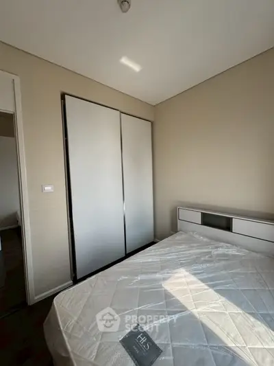 Modern bedroom with sleek wardrobe and natural light, perfect for urban living.