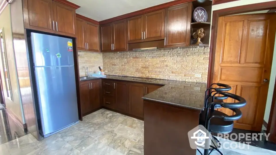 Modern kitchen with wooden cabinets and marble flooring in a stylish home