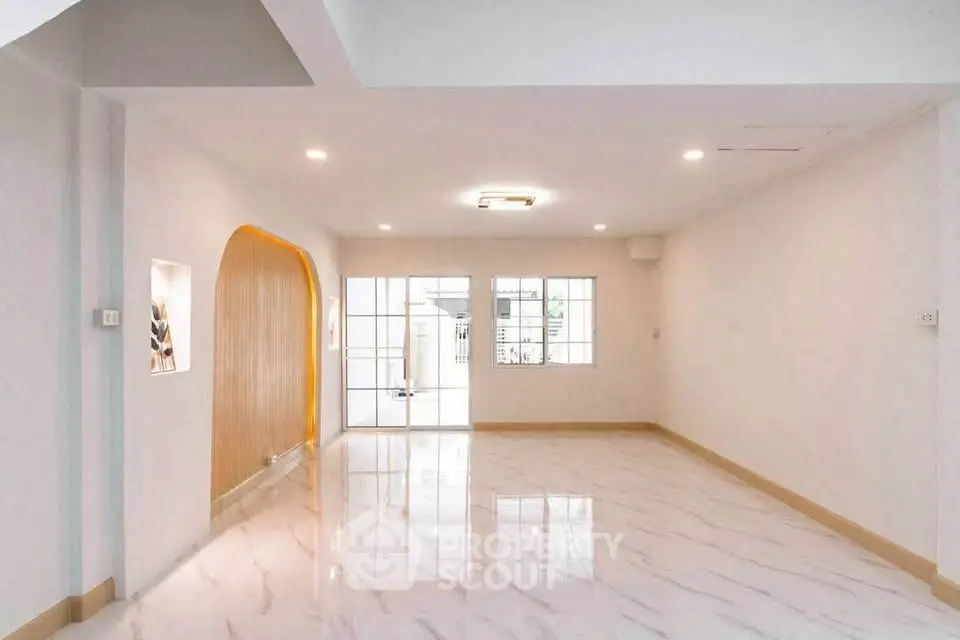 Spacious modern living room with glossy marble floors and large windows