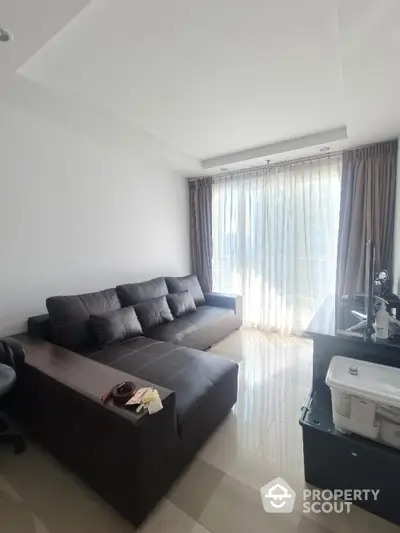 Modern living room with sleek sofa and large window, perfect for natural light lovers.