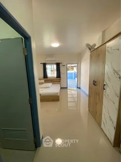Spacious bedroom with modern wardrobe and natural light, perfect for comfortable living.