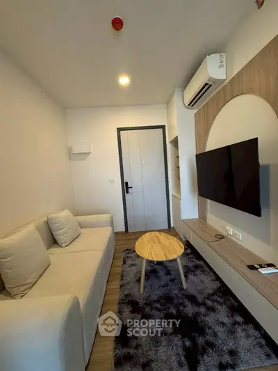 Modern living room with cozy sofa, wall-mounted TV, and stylish decor