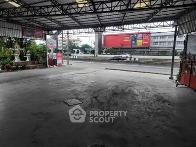 Spacious covered parking area with urban street view, ideal for commercial use or storage.