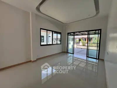 Spacious modern living room with large windows and patio access in a stylish home.