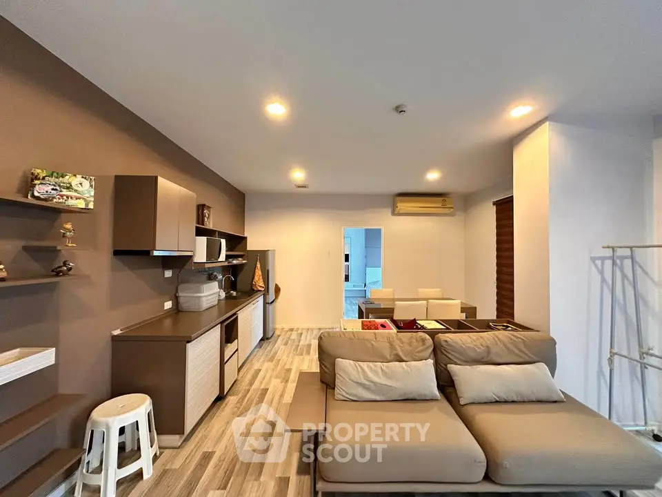 Modern living room with stylish decor and open layout, featuring cozy seating and contemporary shelving.