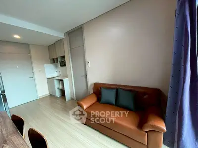Modern apartment interior with cozy leather sofa and compact kitchen
