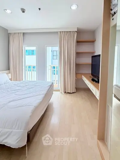 Spacious bedroom with modern decor and natural light, featuring a cozy bed and built-in shelves.