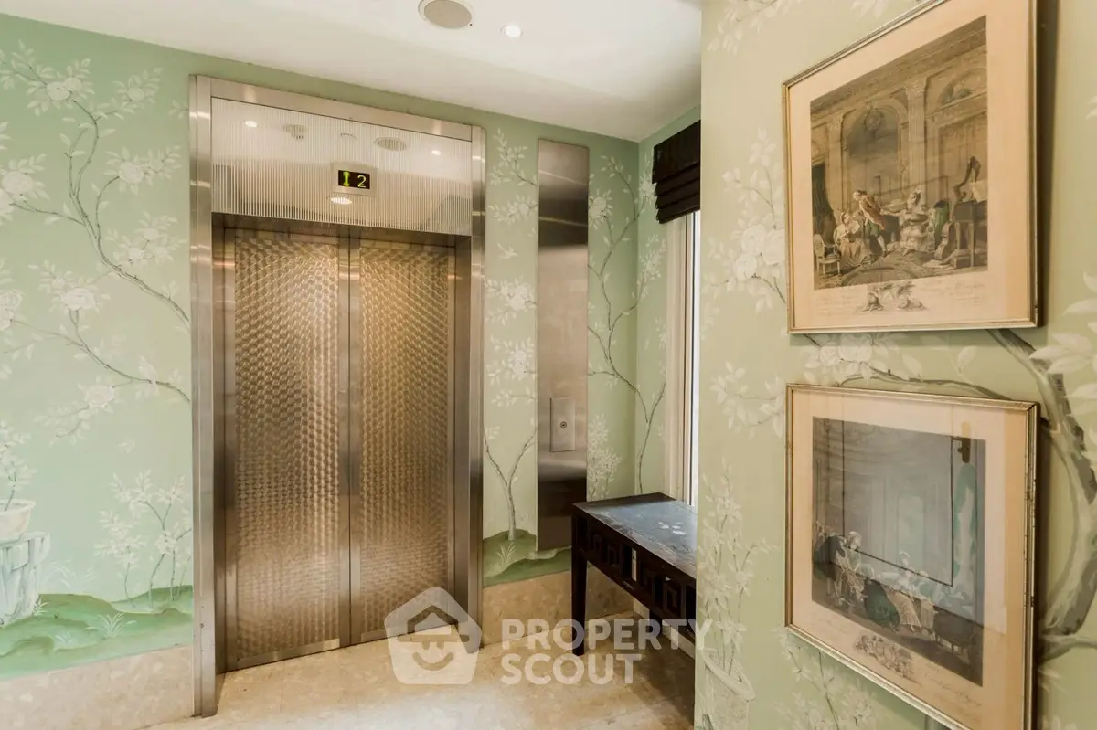Elegant elevator lobby with floral wallpaper and classic artwork