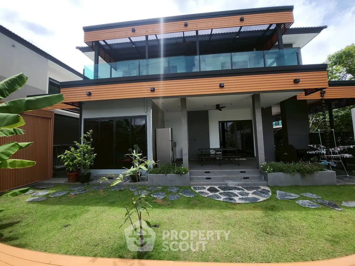 Modern two-story house with spacious balcony and lush green garden