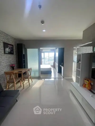 Modern living room with dining area and view of bedroom through glass doors, bright and spacious.