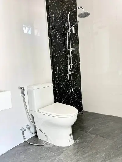 Modern bathroom with sleek black marble shower and contemporary fixtures.