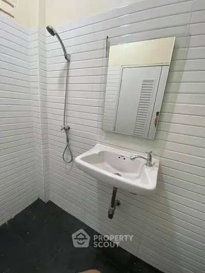 Modern minimalist bathroom with sleek white tiles and wall-mounted sink