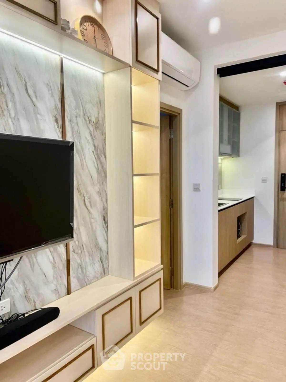 Modern living room with sleek TV unit and open kitchen layout