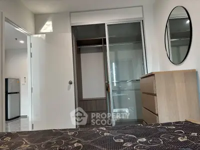 Modern bedroom with sliding closet doors and stylish dresser in a contemporary apartment.