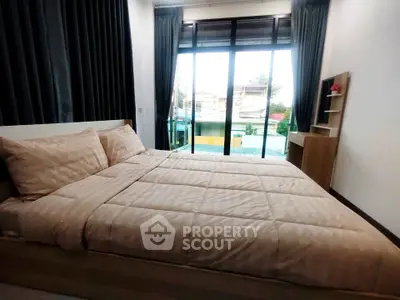 Spacious bedroom with large windows and modern decor, offering a bright and inviting atmosphere.
