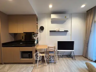 Modern living room with sleek kitchen, air conditioning, and stylish furniture in a cozy apartment.