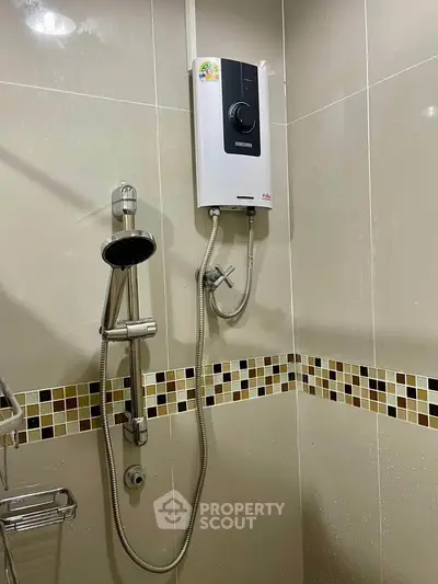 Modern bathroom with sleek shower and water heater, featuring stylish tile accents.
