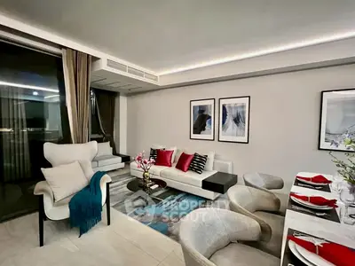 Modern living room with elegant decor and dining area, featuring stylish furniture and contemporary art.