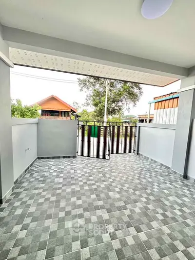 Spacious tiled balcony with modern railing and scenic neighborhood view.