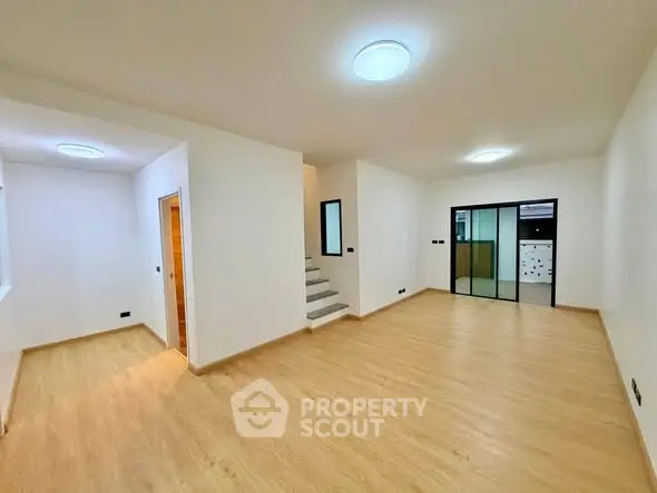 Spacious modern living room with wooden flooring and bright lighting