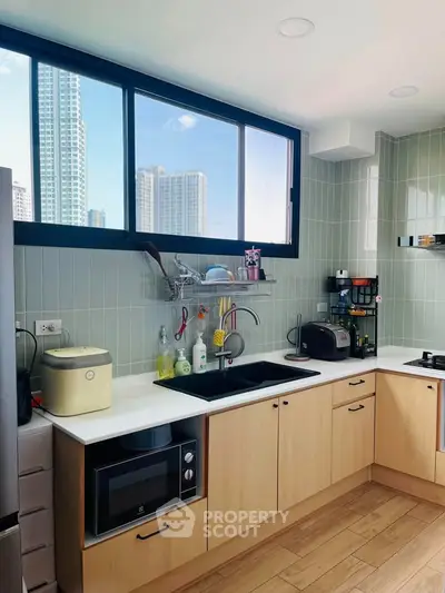 Modern kitchen with city view, featuring sleek cabinetry, built-in appliances, and ample natural light.