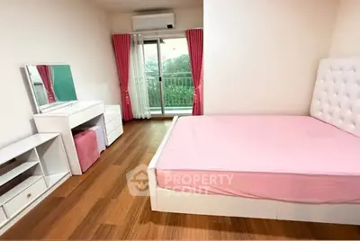 Spacious bedroom with pink accents and balcony access in modern apartment