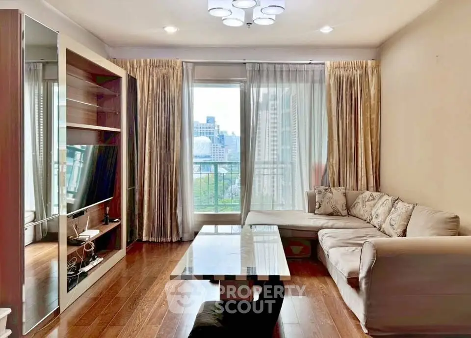 Spacious living room with modern decor and city view, featuring a cozy sofa and elegant lighting.