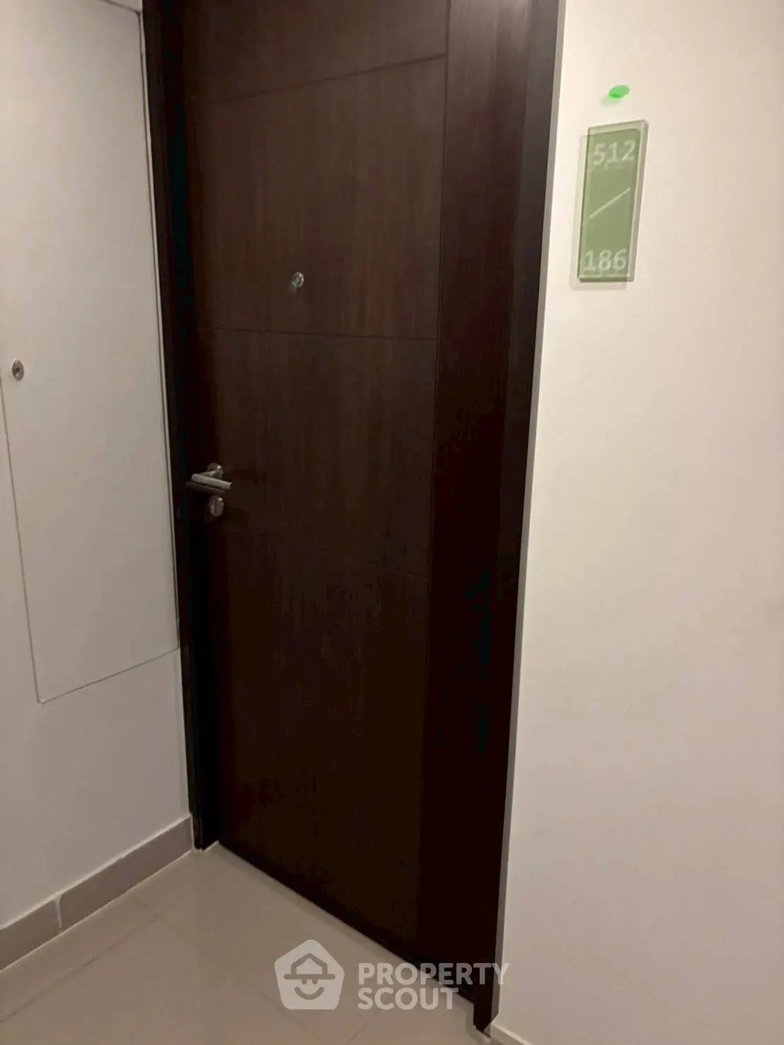 Modern apartment entrance with sleek wooden door and room number signage.