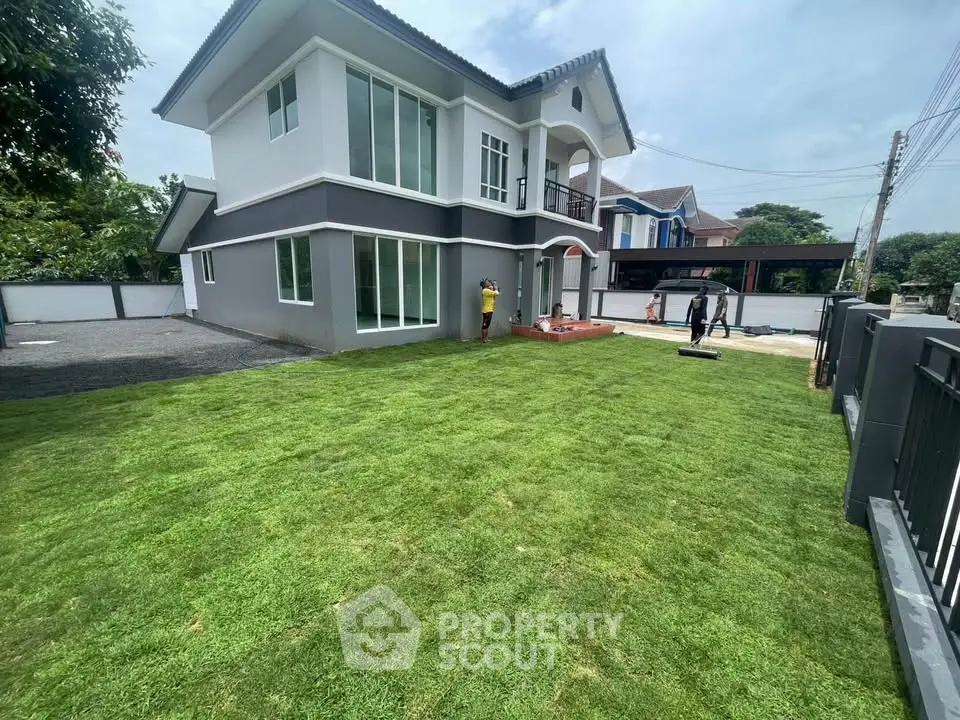 Stunning two-story home with lush green lawn and modern exterior design, perfect for family living.