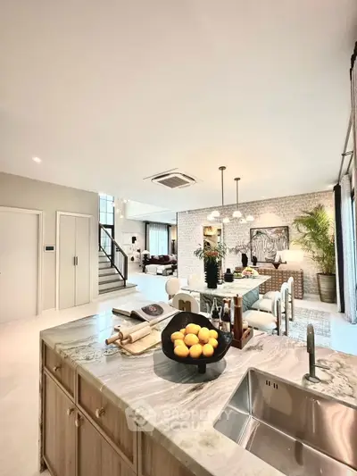 Luxurious open-plan kitchen and dining area with modern decor and natural light.