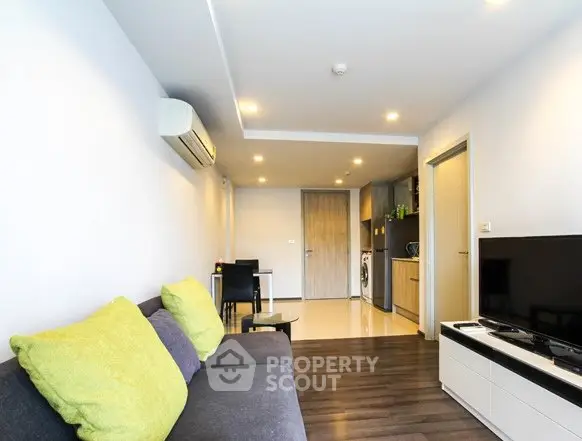 Modern living room with sleek furniture and open kitchen layout in a stylish apartment.