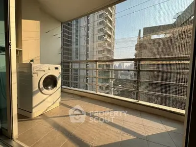 Spacious balcony with washing machine and city view in modern apartment.
