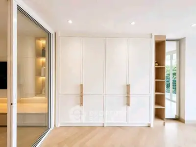 Spacious modern living room with built-in storage and large windows for natural light.